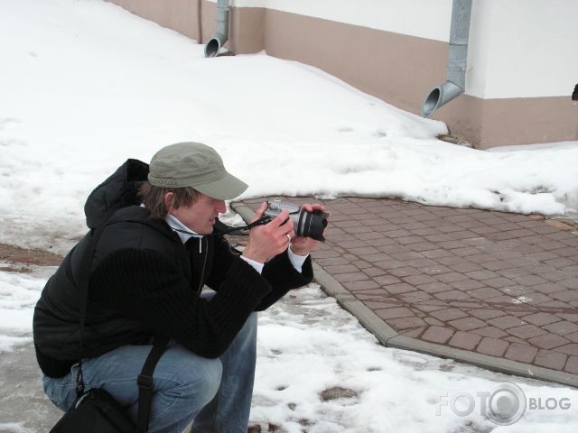 soli solī blakus cilvēkam ar fotokameru